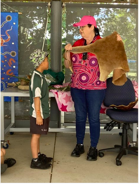 Student engaging in a cultural learning experience with a community educator, supporting understanding, respect and shared cultural knowledge