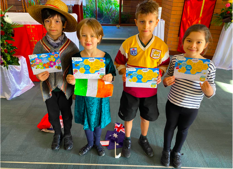 Students holding learning certificates and cultural symbols, recognising participation, achievement and cultural celebration