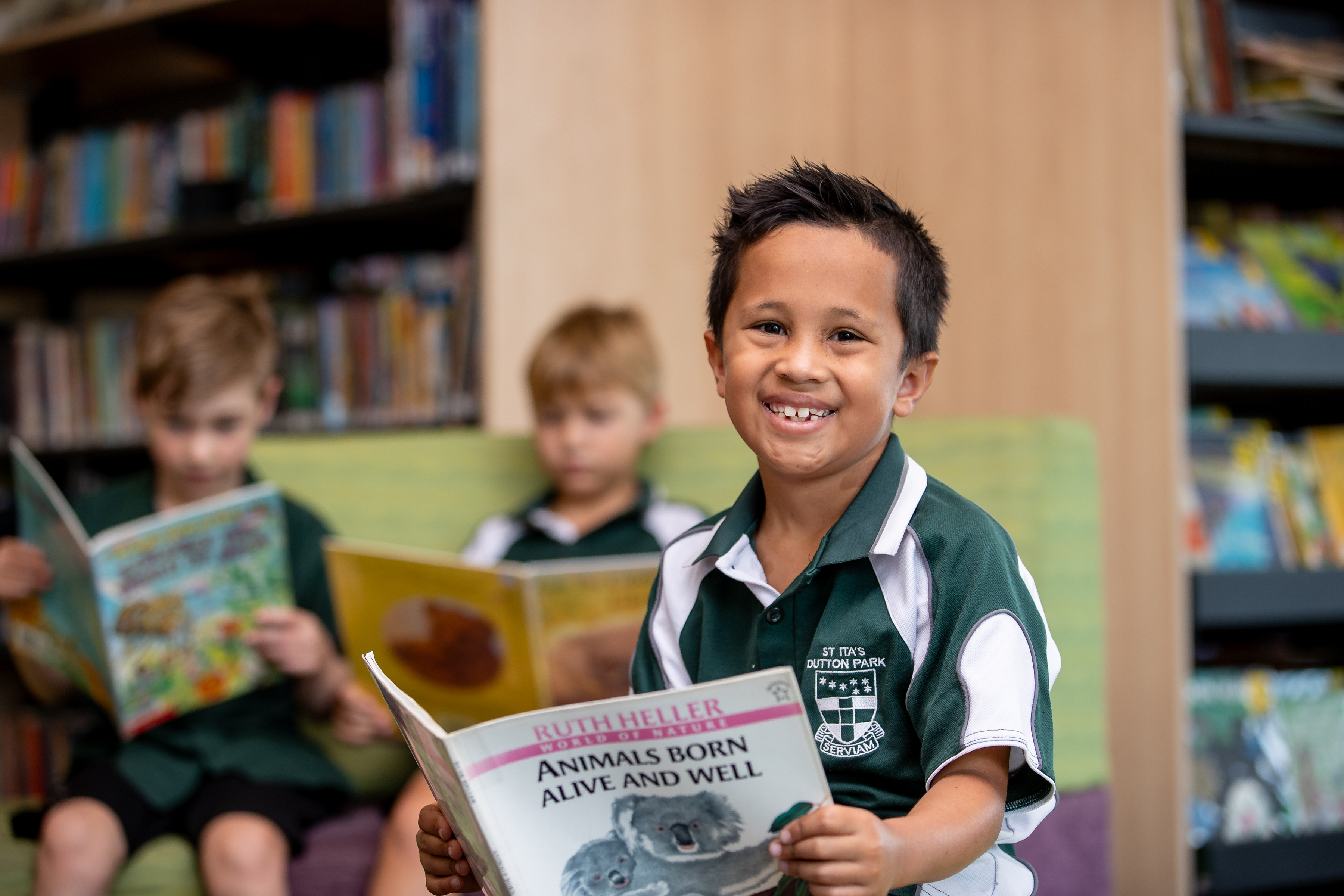 Student reading a book in the school library, highlighting engagement with reading, literacy development and a welcoming learning environment